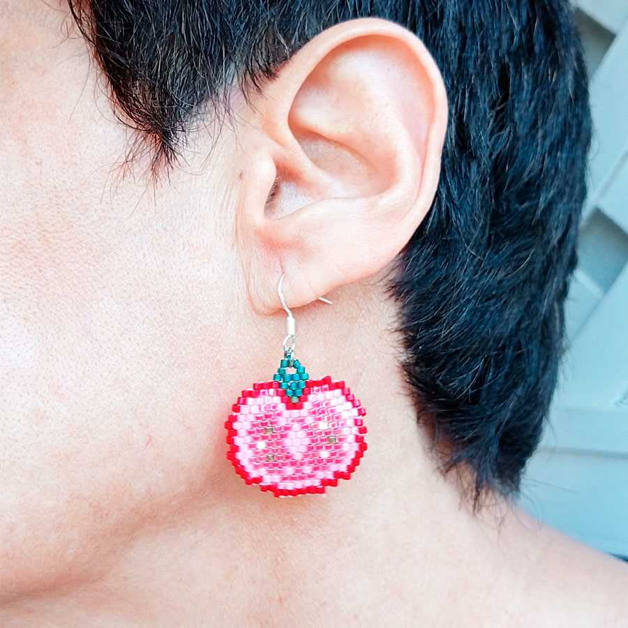 Pendientes Tomates de Cuentas • Joyas Coquetas vista del tamño real de los pendientes puestos en la oreja de una modelo