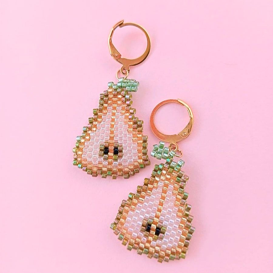 Pendientes Fruta Pera • Joyas Coquetas Vista frontal sobre fondo rosa de los pendientes fruta pera artesanales. Hechos a mano por Joyas Coquetas en España.