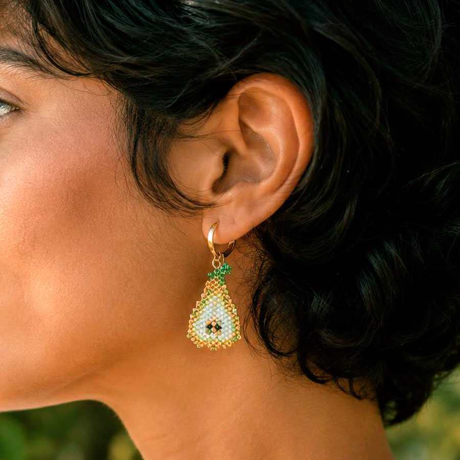 Pendientes de pera Miyuki puestos en oreja con aro dorado, hechos a mano por Joyas Coquetas en Málaga