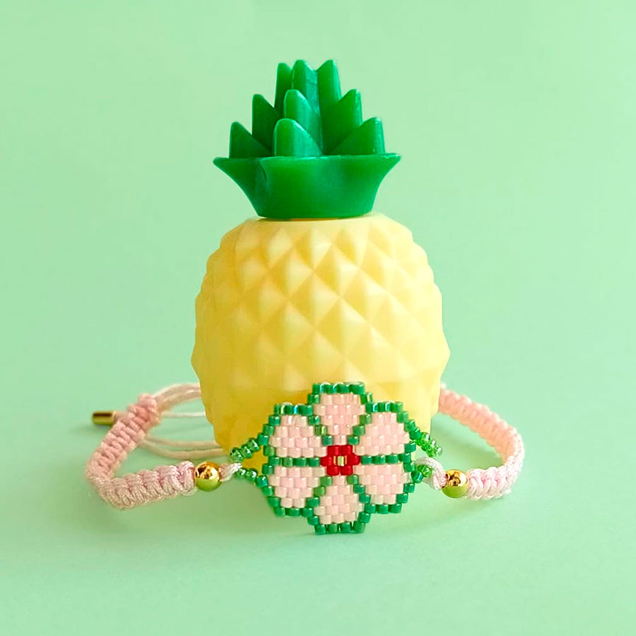 Pulsera Flor Rosa - El toque femenino que le faltaba a tu look • Joyas Coquetas Accesorio femenino con dije de flor rosa y borde verde sobre fondo alegre, hecho a mano por Joyas Coquetas en Málaga.