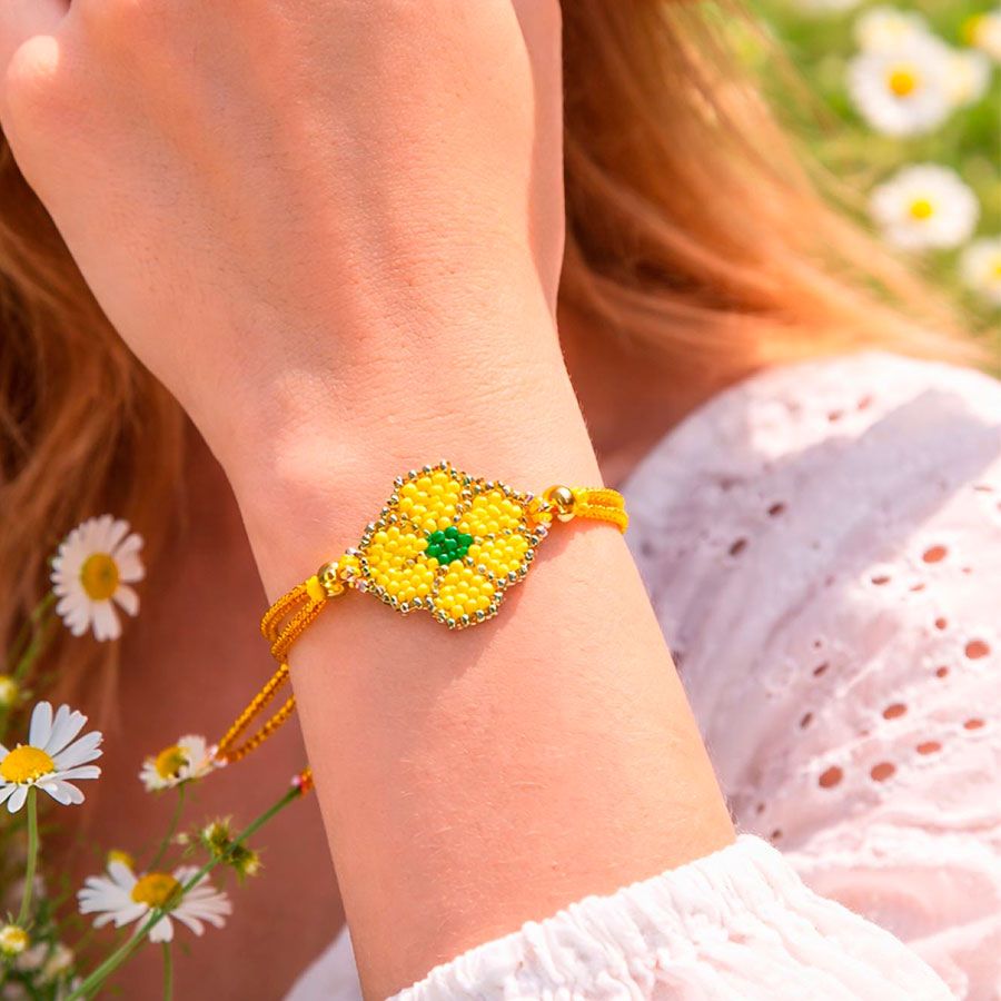 Pulsera flor amarilla puesta en la muñeca de una modelo. Es una joya hecha a mano por Joyas Coquetas en España.