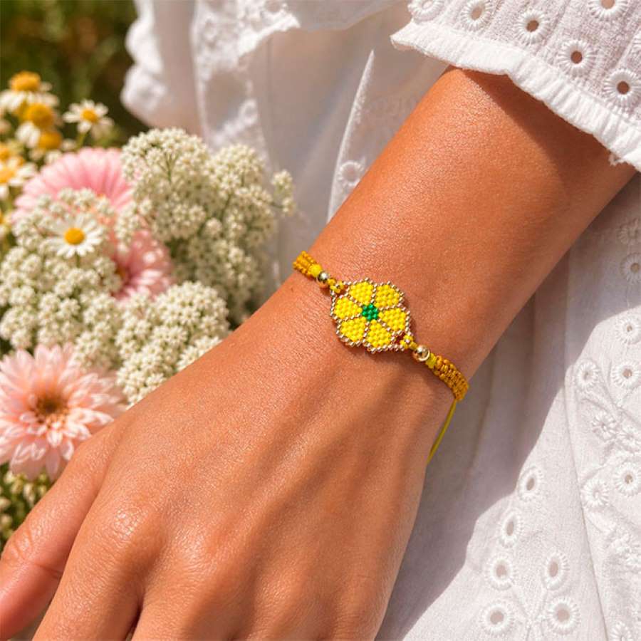 Pulsera de flor amarilla en muñeca estilo boho hecha a mano por Joyas Coquetas en Málaga