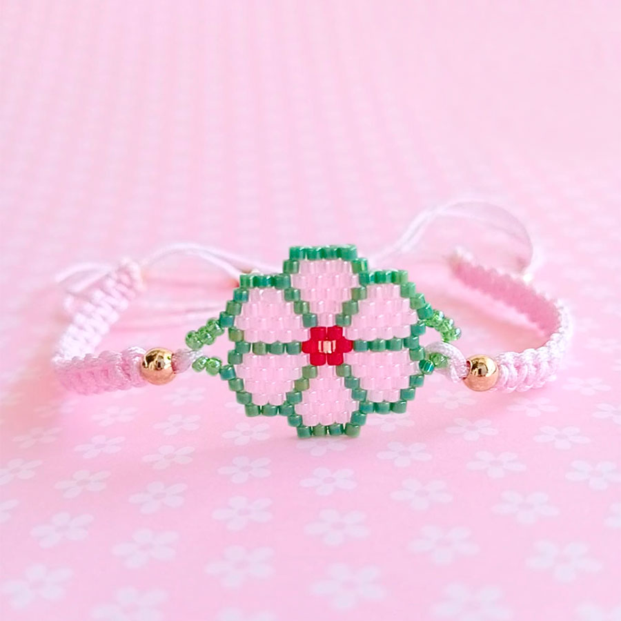 Pulsera Flor Rosa - El toque femenino que le faltaba a tu look • Joyas Coquetas Pulsera con flor rosa sobre fondo aesthetic de lunares, hecha a mano por Joyas Coquetas en Málaga.