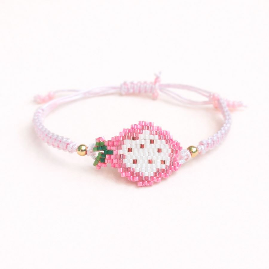 Pulsera ajustable pitaya, artesanal y hecha a mano con cuentas de cristal Miyuki y cordón ajustable macramé. Foto hecha sobre fondo blanco por Joyas Coquetas en Europa.