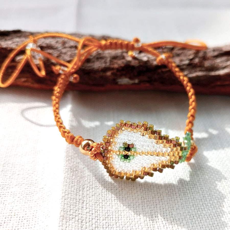 Pulsera ajustable pera artesanal tejida a mano con cuentas Miyuki y cordón macramé mostaza. Hecha por Joyas Coquetas en Málaga, España