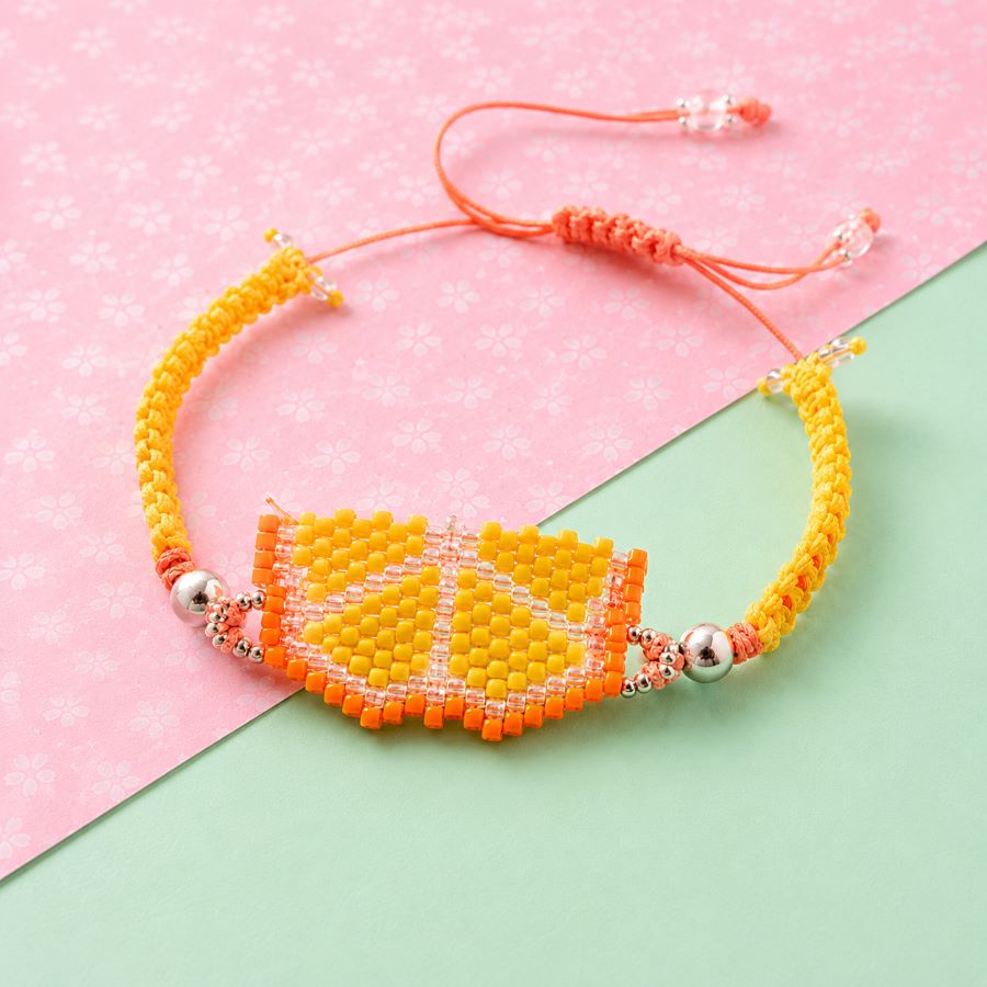 Pulsera Fruta Naranja Miyuki • Joyas Coquetas Pulsera Fruta Naranja Miyuki sobre fondo rosa y verde en composición creativa, hecha a mano por Joyas Coquetas en Málaga.