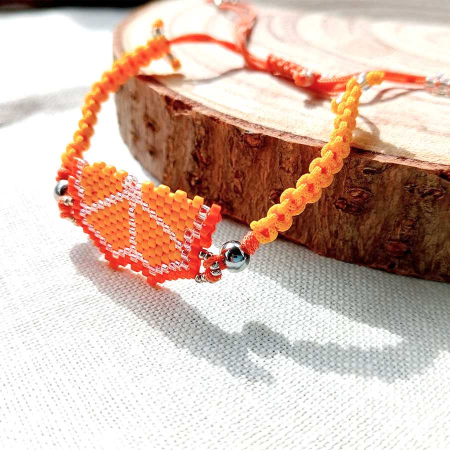 pulsera frutal naranja, hecha a mano con cuentas de cristal Miyuki y cordón tejido en macramé. Hecha por Joyas Coquetas en Málaga, España