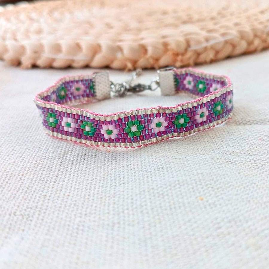 pulsera artesanal miyuki. Alegre pulsera de color morado con margaritas de colores. Hecha a mano por Joyas Coquetas en Málaga.