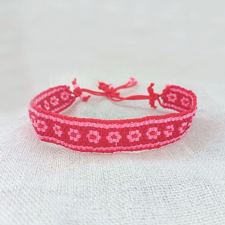 Joyas Coquetas y Divertidas hechas a mano • Joyas Coquetas Pulsera Miyuki flores rosa y roja hecha a mano sobre fondo de tela clara. Diseño de Joyas Coquetas