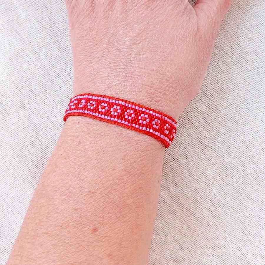 Pulsera Miyuki Flores • Joyas Coquetas Pulsera Miyuki flores rosa y roja hecha a mano colocada en la muñeca. Hecha a mano por Joyas Coquetas en Málaga, España