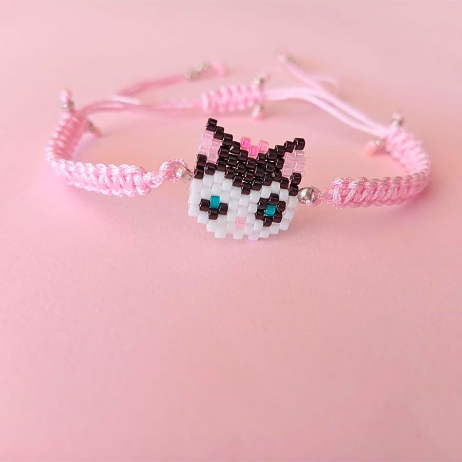Joyas Coquetas y Divertidas hechas a mano • Joyas Coquetas Pulsera Gatita Lazo Rosa hecha a mano con cuentas Miyuki sobre fondo rosa pastel. Hecha por Joyas Coquetas en España.