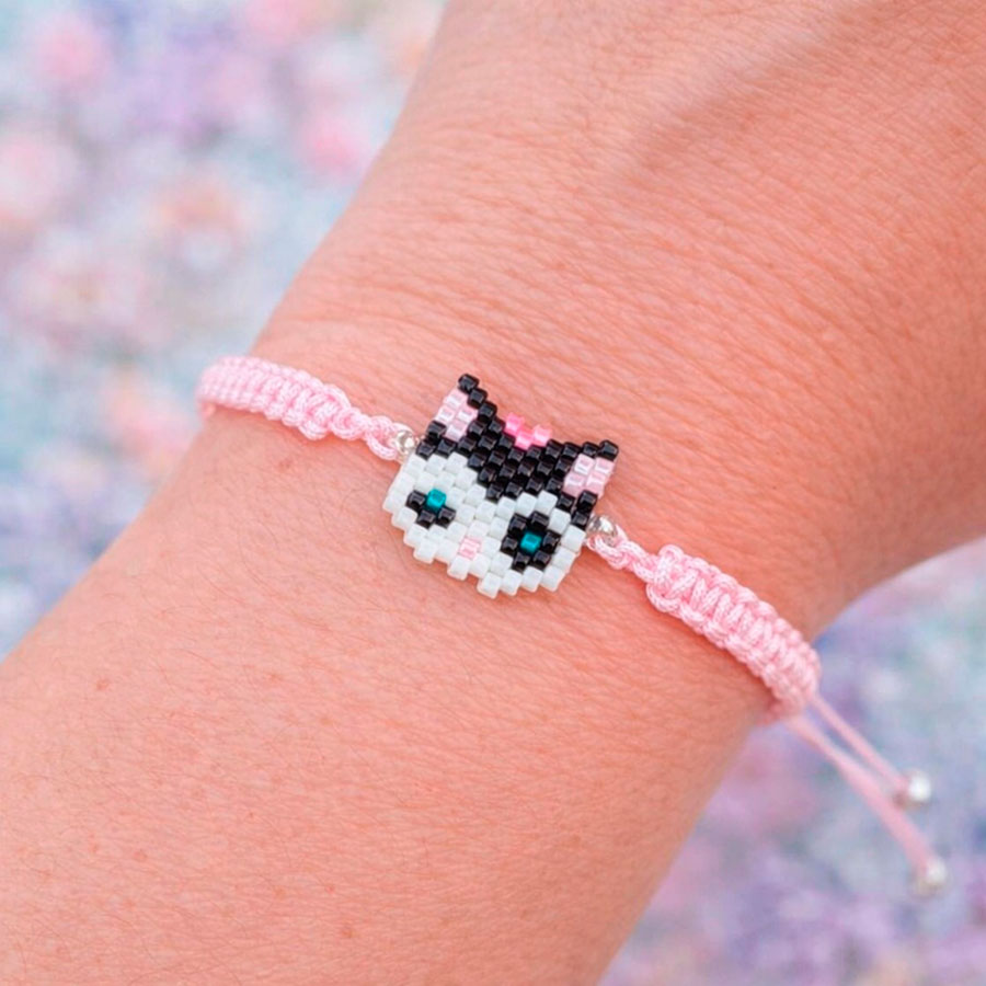 Pulsera Gatita Lazo Rosa • Joyas Coquetas Pulsera Gatita Lazo Rosa puesta en muñeca mostrando tamaño real del charm de 1 cm por 1,5 cm. Hecha a mano por Joyas Coquetas en España.