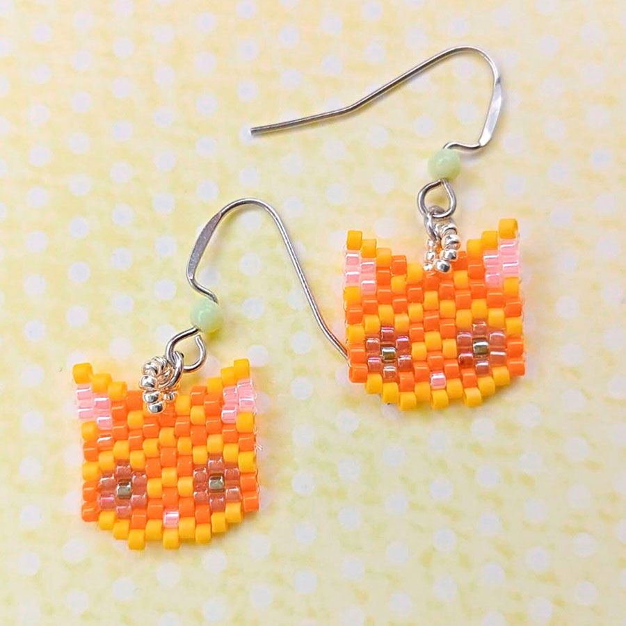 Pendientes gato naranja • Joyas Coquetas pendientes gato naranja miyuki sobre fondo amarillo. Hechos a mano por Joyas Coquetas en España.